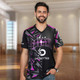 A man wearing a black and purple custom sports V-neck T-shirt with a logo. The shirt features a bold, modern design.