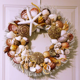 Seashell wreath with exotic sea urchins on white birch twig
