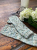 The Trailing Vines Cowl & Mitt pattern set by Wonderland Yarns features and delicate lace pattern that uses simple stitches, allowing both the cowl and mitts to be knit quickly with just one skein.