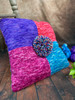 Bold, bright, and full of personality, this colorful pillow by Deborah George adds a playful pop to any space. Made with eight vibrant shades and topped with a cheerful pom-pom, it’s as fun as it is cozy.