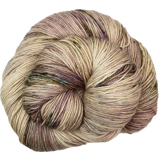 "Toadstool" has a creamy brown base that is full of highs and lows, with added watercolor splashes of lilac, and specks of spring green, blues, and dark grays. Available to order from Wonderland Yarns on any yarn base. Dyed to order in Vermont.