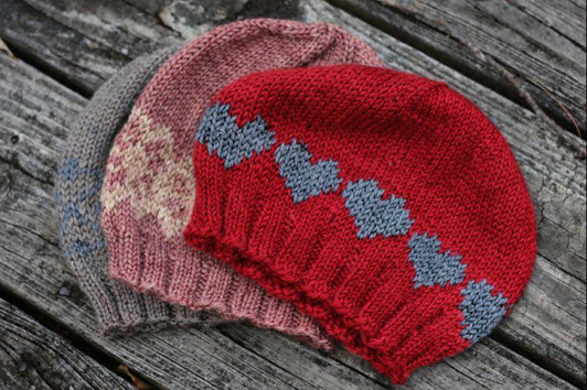 The pattern includes three options: a plain hat, an optional charted “resist” motif, or a heart motif — because love wins. Choose the version that speaks for you.