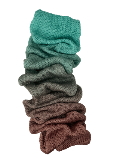 Blue Star Fern is a hand-dyed gradient cake of yarn from Wonderland Yarns that transitions from a sepia brown to teal