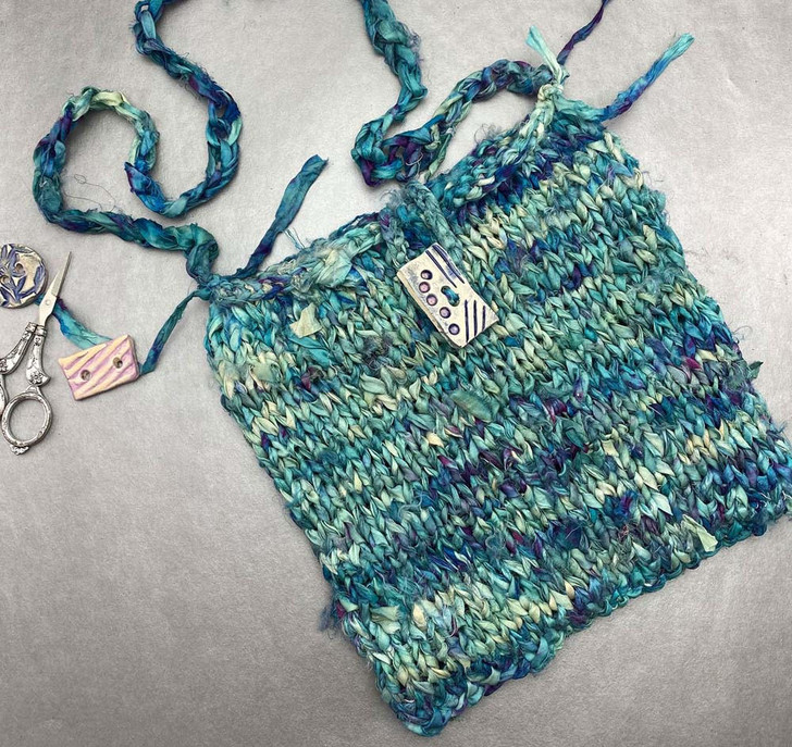 Mermaid's Purse-Use one or two skeins of our hand-dyed Watercolor Sari Ribbon to knit this simple, yet striking bag.  The texture of the ribbon and the sheen of the silk make even simple knitting eye-catching. Free pattern available for download. Free pattern available for download.