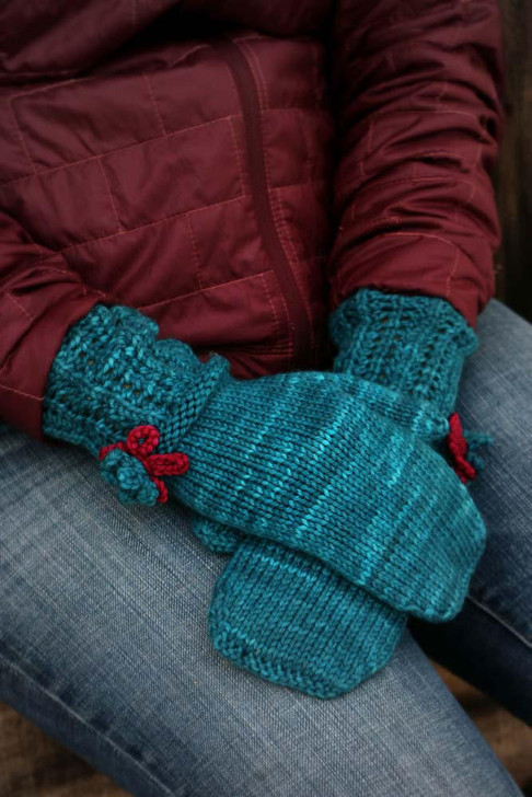 Storybook Mittens- These whimsical mittens feature a lace cuff and contrasting color crochet flowers. Free pattern available for download.