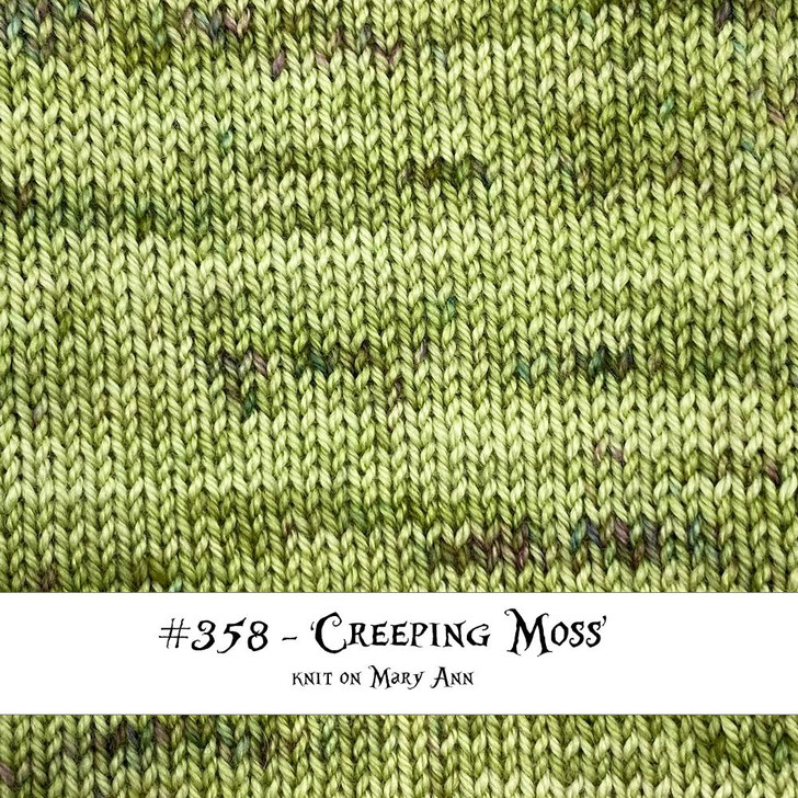 A knit swatch of "Creeping Moss" shows off the subtle speckles of burgundy and blue from Wonderland Yarns hand-dyed collection Off the Path. Dyed to order in the USA.