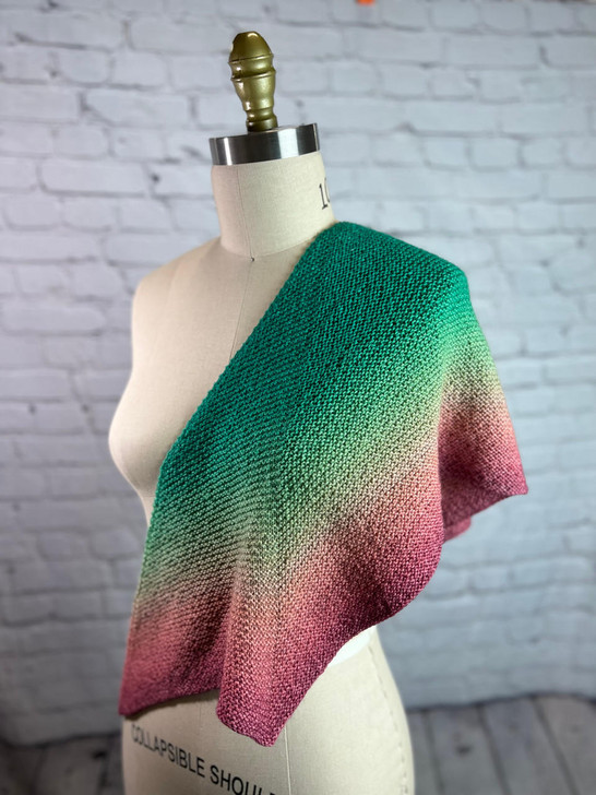 Another great design by guest designer Joanna Curley, this simple shawlette uses carefully placed increases to creates a half hexagon shape that’s easy to wear. Featured in a Blossom gradient cake the simple stitchwork lets the color transitions shine.