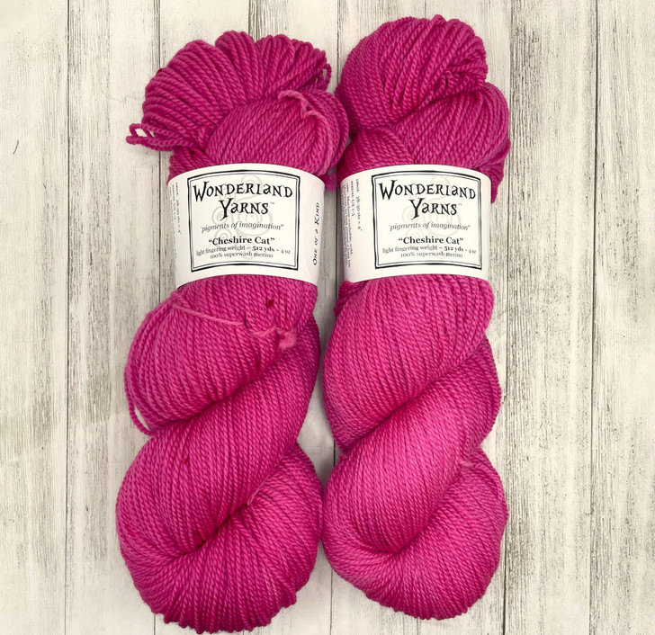 Wonderland Yarns Cheshire Cat, light fingering One-of-a-Kind Yarn. This colorway  features a vibrant pink base,  with specks of magenta.