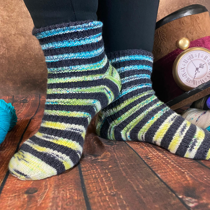 These fun striped socks by Joanna Curley will have you doing a happy dance when you feel how comfortable these are when they hug your feet! Using 5 mini skeins of Queen of Hearts yarn by Wonderland Yarns, these silky soft socks with ribbing detail will be just perfect to add to your collection!