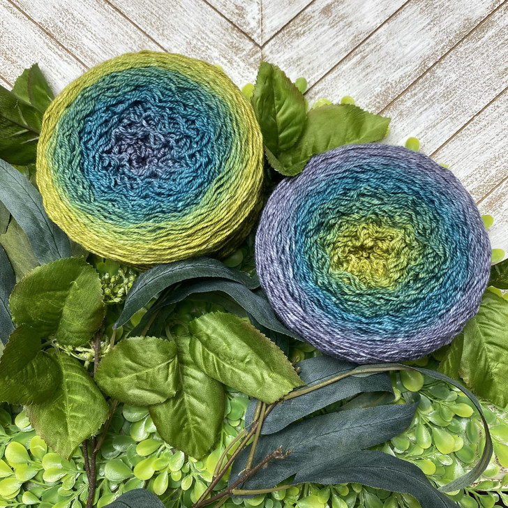 A hand-dyed gradient cake of yarn from Wonderland Yarns. This cake starts with a slate grey, to teal, then morphs into chartreuse. The colors magically meld together for a seamless color transformation!