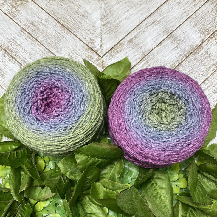 A floral inspired hand-dyed gradient cake of yarn from Wonderland Yarns. This cake morphs from magenta, to a cool lavender, then into a light green. The colors magically meld together for a seamless color transformation!