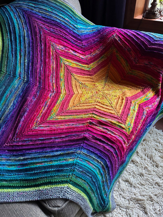 A collection of 20 hand-dyed mini skeins in a bright, riot of color has been knit into this blanket.