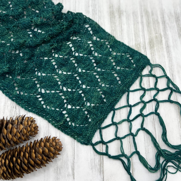 Evoking the fabulous foliage of the forest, the rhythmic leaf lace pattern of the Sherwood Scarf by Wonderland Yarns is polished off with a simple, yet elegant, knotted fringe that takes this light-weight scarf from basic to romantic.