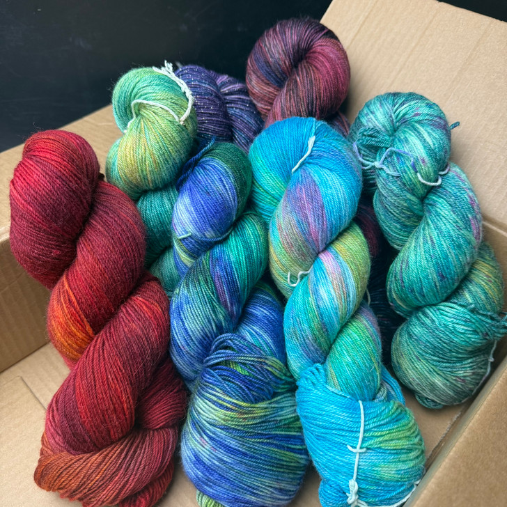 This is an example of how much yarn is included in a Guest Yarn mystery box! A range of weights, colors, dye styles, and more can be added. Extra mystery goodies not shown.