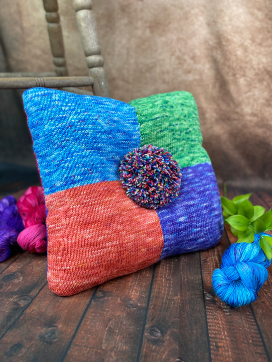 Bold, bright, and full of personality, this colorful pillow by Deborah George adds a playful pop to any space. Made with eight vibrant shades and topped with a cheerful pom-pom, it’s as fun as it is cozy.