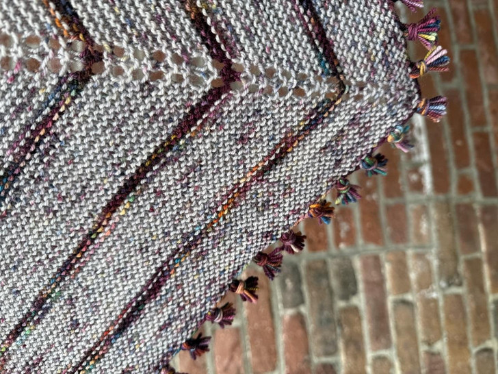 The simple stripes of this shawl pattern let the fringe do the storytelling, adding quiet drama at the edges.