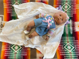 Close up of baby doll in beaded moccasins