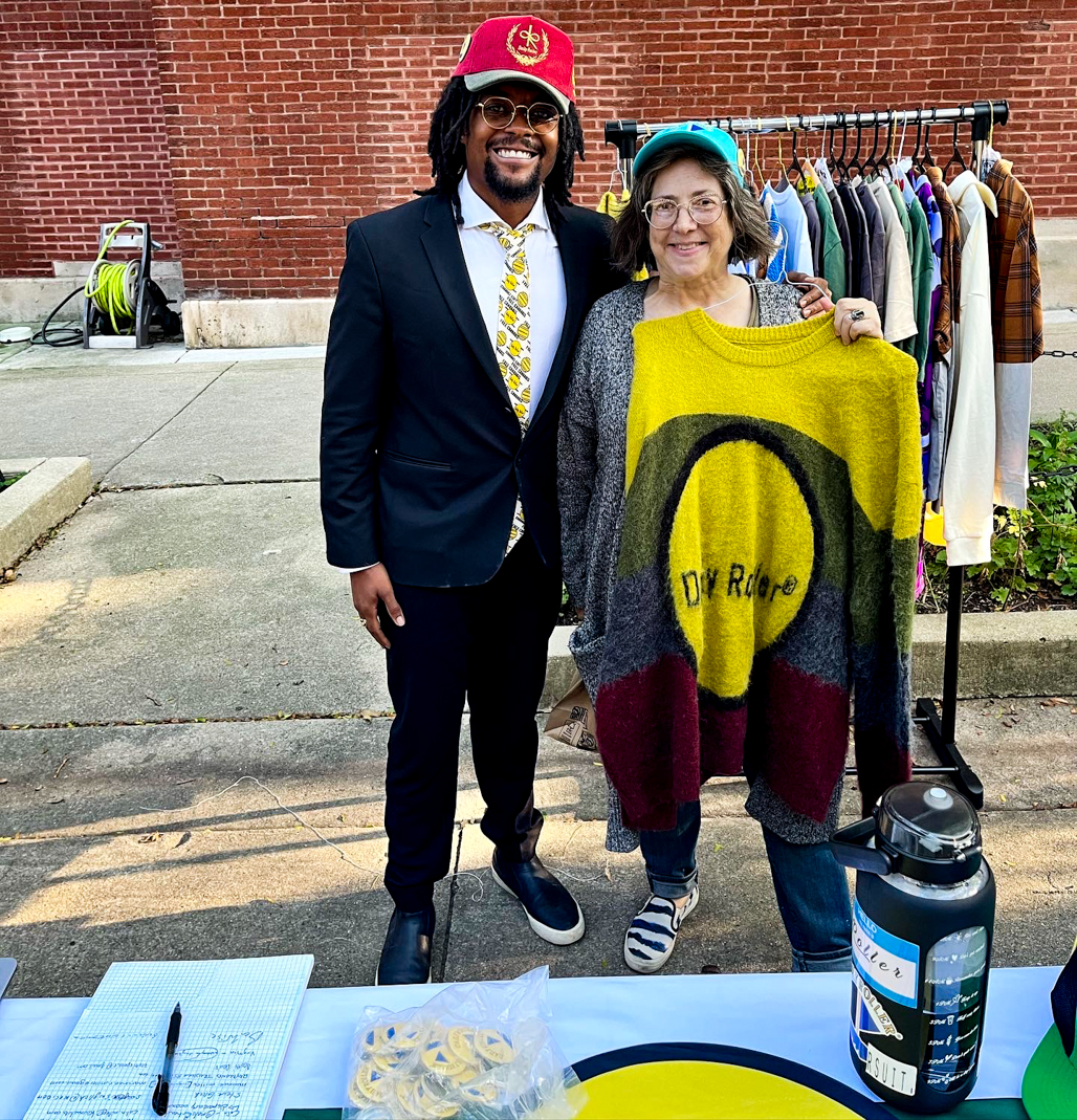 Daily Roller Founder CEO Designer at Uptown Chicago Farmer Market with Customer Holding Roots Core Collection Round Neck 