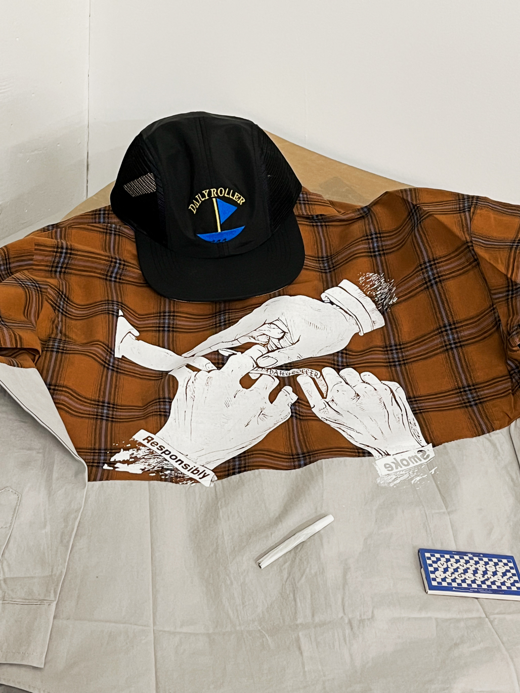 FRONT FLATLAY_ASSYMETRIC CROPPED CLASSIC SOFTBALL SLEEVE WHITE_ SMOKE RESPONSIBLY SOUVENIR FLANNEL LIFESTYLE IMAGE