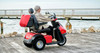 Afikim Afiscooter S3 3-Wheel Scooter, red, lifestyle, rider on a pier