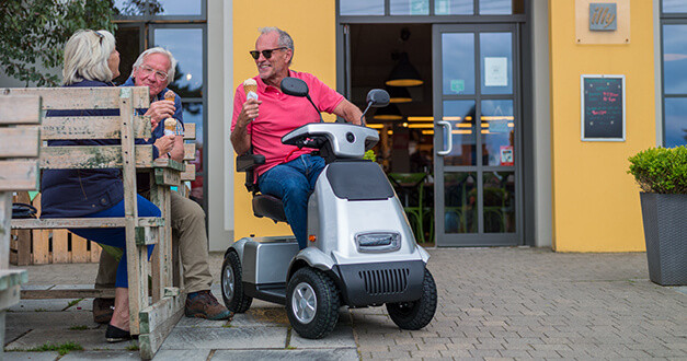 Afikim Afiscooter C4 4-Wheel Scooter, silver, lifestyle, riders at a cafe