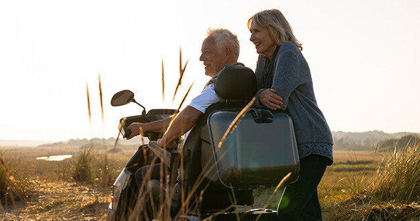 Afikim Afiscooter S3 3-Wheel Scooter, gray, lifestyle, couple in the dunes