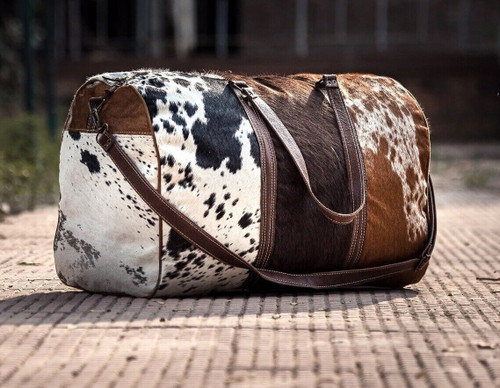 The stylish cowhide duffel bag is a timeless accessory that makes a bold style statement. Crafted out of the finest quality leather, this exquisite piece exudes an air of sophistication and class. 