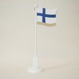 White table flag pole with Finland flag on a light background.