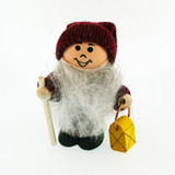 Wooden tomte figurine wearing a red knit hat, holding a walking stick and yellow lantern.