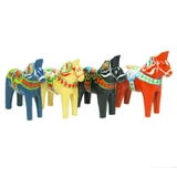Three colorful, wooden Dala horses. Blue, black, and red with traditional painted details.