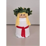 Mini Lucia doll with blonde hair, green leaf crown, white dress, and red sash.