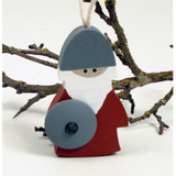 Wooden Viking ornament, gray helmet, red tunic, white beard, gray shield, hanging string, on branches.