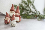 Four ceramic Naasgransgarden Lille Luva Tomte figurines with red pointy hats and pine branches.
