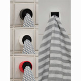 Black, white, and red dishcloth hangers on tiled wall, one with striped towel.