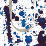 Close-up of a blue and purple paint splatter pattern on a white gift bag with cord handles.