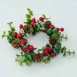 Candle ring with pinecones, red berries, and green leaves on white.