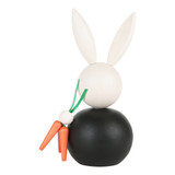 Handmade wooden Aarikka Pupujussi bunny figurine in black, holding orange carrots.