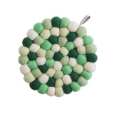 Circular wool felt ball trivet in a mix of green, white, and dark green shades.