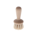 A wooden face brush with white horsehair bristles, angled slightly to the right on white.