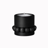 Matte black Aarikka Prinsessa tealight candle holder with wooden beads and a single white candle.