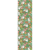 Green table runner with a repeating pattern of white hopping hares and colorful floral illustrations.