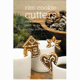 Three gingerbread cookies shaped like a house, star, and heart, decorated with white icing and perched on white coffee mugs.