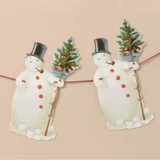 Two paper snowman cutout ornaments on a red string, wearing black top hats and holding decorated trees.