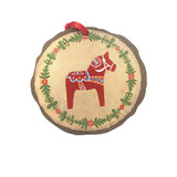 Circular wooden ornament with red Dala horse, green leaf wreath, and red hanging ribbon.
