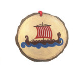 Hand-painted wooden slice ornament featuring a Viking ship with red sails on blue waves, with a red hanging ribbon.