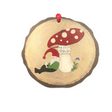 Round wooden ornament with a gnome reading under a mushroom.