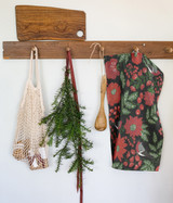 Ekelund Julfaglar kitchen towel with red floral pattern hanging on a wooden hook.
