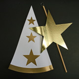 White paperboard hat with gold stars, gold star wand, black background.