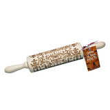 Wooden embossing rolling pin with an etched folk pattern, angled horizontally with a recipe tag.