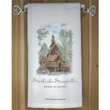 A white flour sack towel with a watercolor illustration of a wooden stavkirke church, hanging on a rustic towel holder.